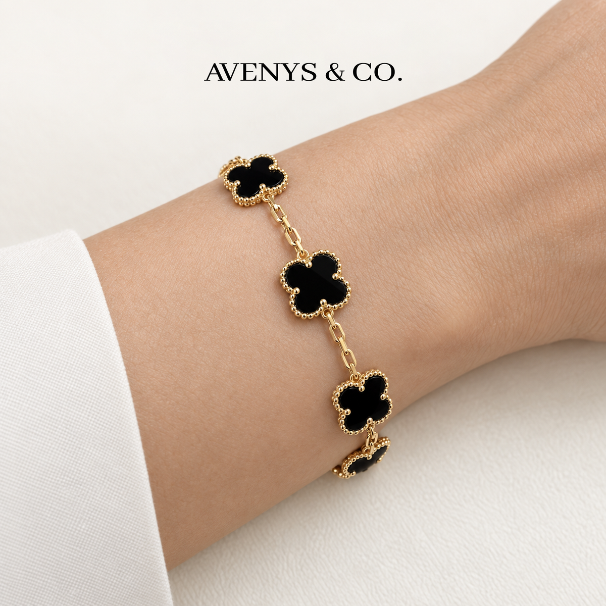 Black five-motif bracelet in yellow gold worn on a wrist